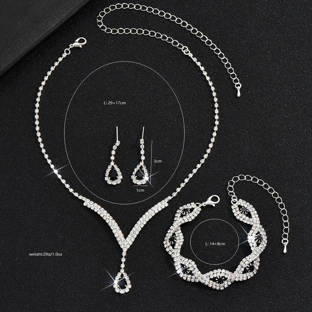 Luxury Silver Jewelry Set with Black Stones A sophisticated set comprising a necklace, earrings, and bracelet, all adorned with teardrop-shaped black stones and sparkling crystal accents. Perfect for special occasions.