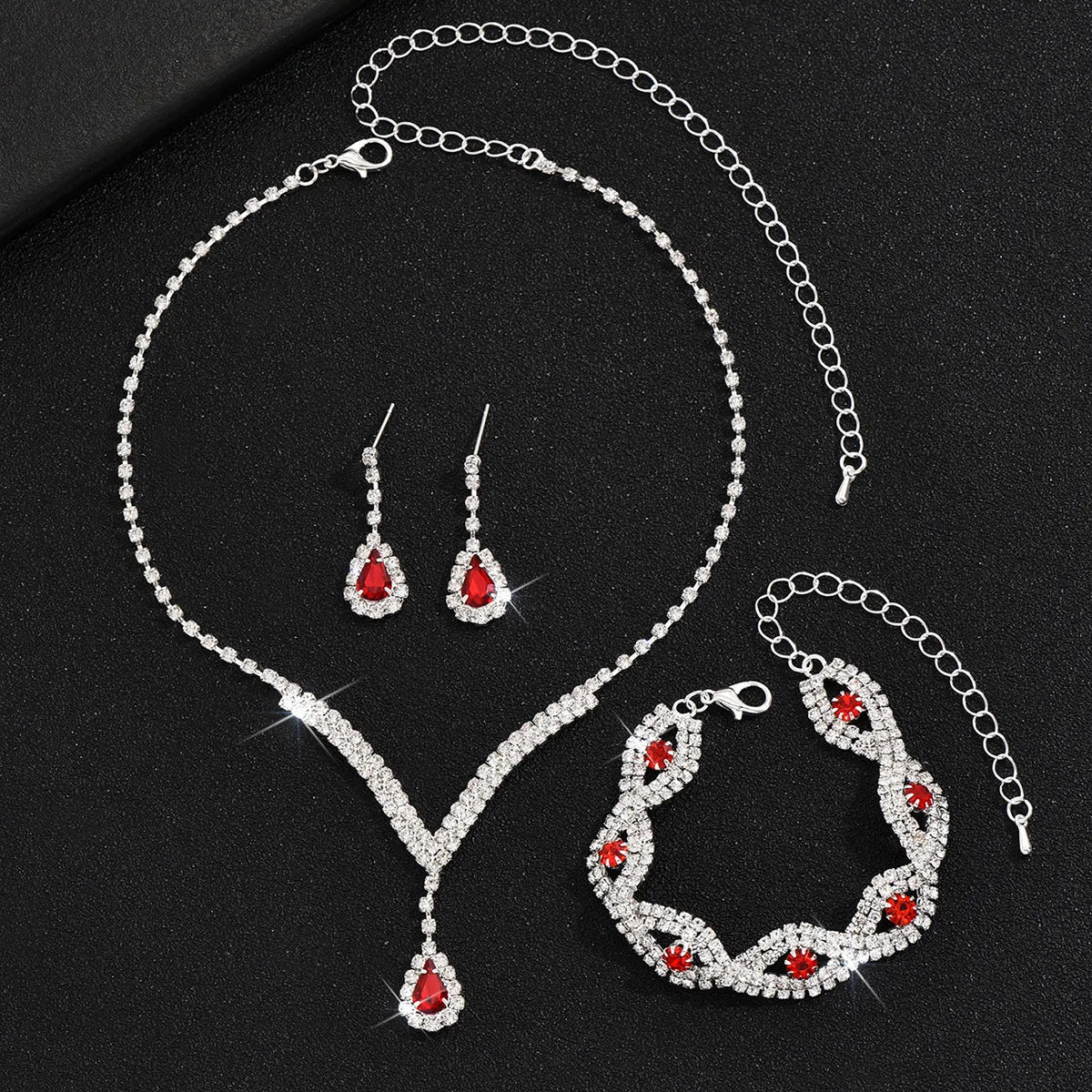 Luxury Silver Jewelry Set with Black Stones A sophisticated set comprising a necklace, earrings, and bracelet, all adorned with teardrop-shaped black stones and sparkling crystal accents. Perfect for special occasions.