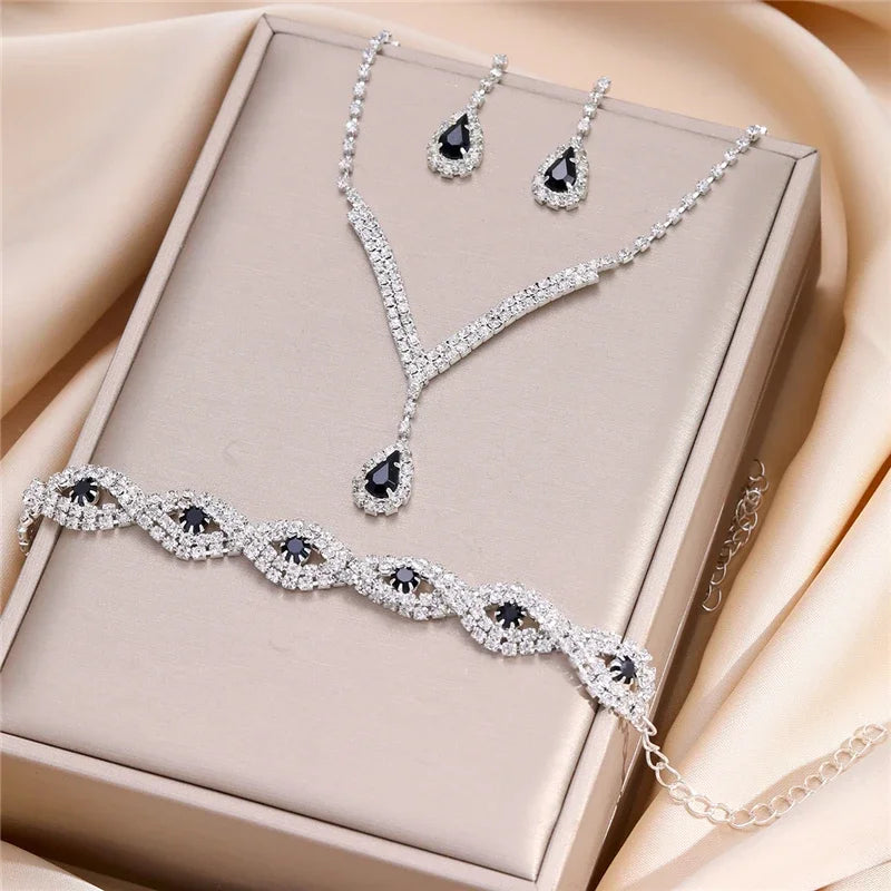 Luxury Silver Jewelry Set with Black Stones A sophisticated set comprising a necklace, earrings, and bracelet, all adorned with teardrop-shaped black stones and sparkling crystal accents. Perfect for special occasions.