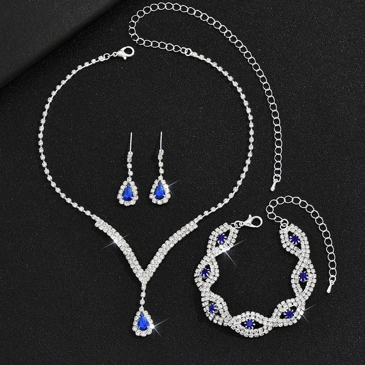 Luxury Silver Jewelry Set with Black Stones A sophisticated set comprising a necklace, earrings, and bracelet, all adorned with teardrop-shaped black stones and sparkling crystal accents. Perfect for special occasions.